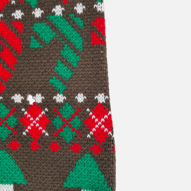 Close-up of a brown fabric with red, green, and white Christmas-themed pattern on a white background.