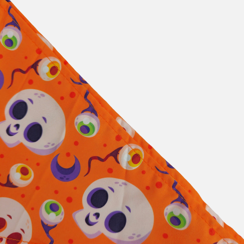 Halloween-themed fabric with skulls and eyeballs on an orange background.