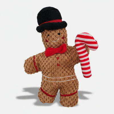 Gingerbread-shaped Christmas plush dog toy with soft textured fabric, red bow, and built-in squeaker.